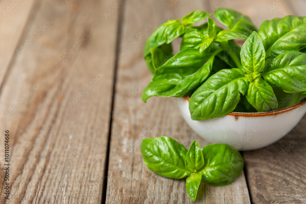 Green basil leaves on a textured wooden background. Kitchen herbs, spices. Fresh green organic basil. Vegan. Greens for salad. Place for text. Copy space. Green basil leaves on a textured wooden background. Kitchen herbs, spices. Fresh green organic basil. Vegan. Greens for salad. Place for text. Copy space.