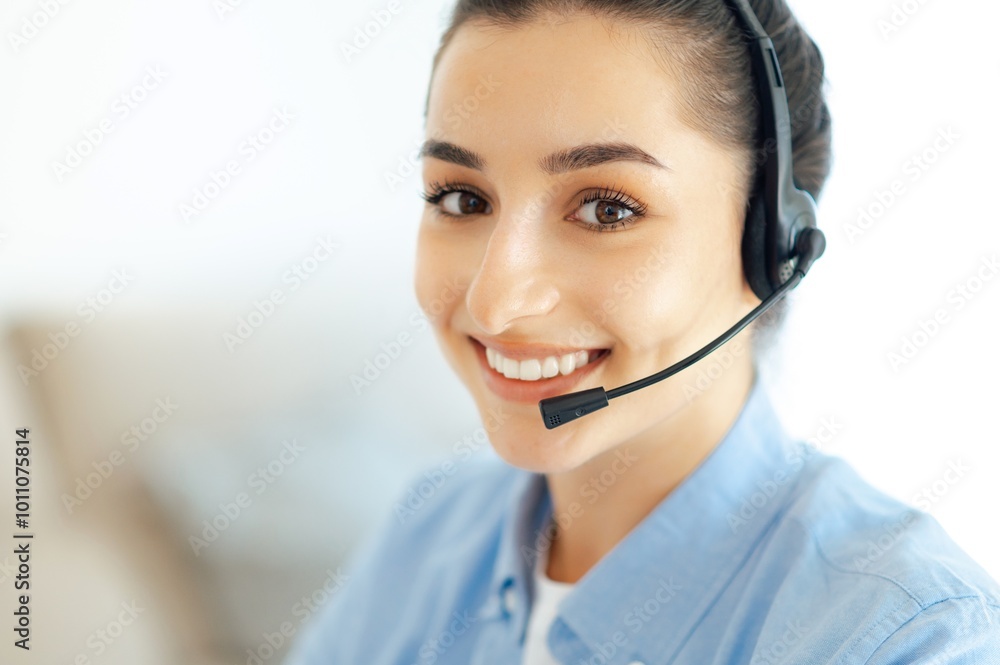 Close-up of charming successful caucasian brunette woman with wireless headset, working in customer support service or helpline, female call center agent, business advicer, smiles at camera Close-up of charming successful caucasian brunette woman with wireless headset, working in customer support service or helpline, female call center agent, business advicer, smiles at camera