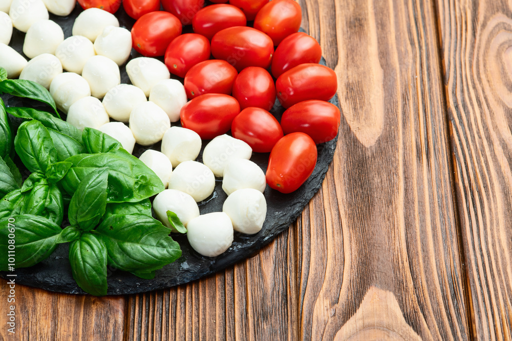 Basil leaves , cherry tomatoes and mozzarella cheese . In form italian flag food photography Basil leaves , cherry tomatoes and mozzarella cheese . In form italian flag food photography