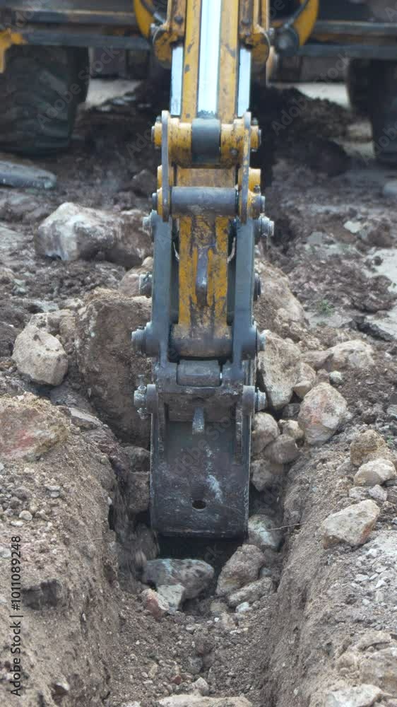 Excavator Arm Digging a Trench in the Ground Excavator Arm Digging a Trench in the Ground