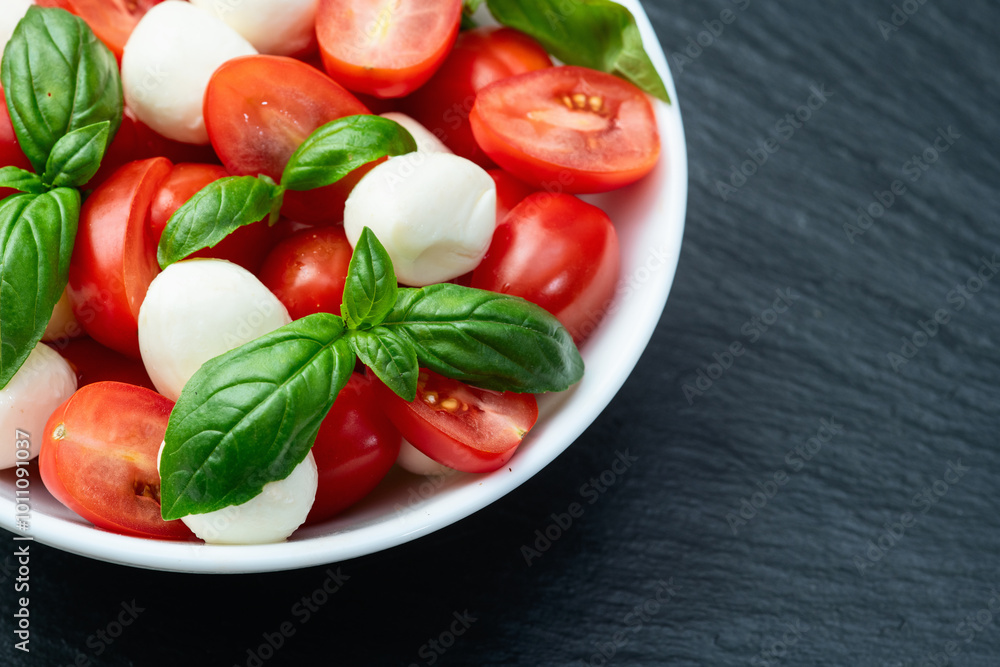 Basil leaves , cherry tomatoes and mozzarella cheese . In bowl food photography Basil leaves , cherry tomatoes and mozzarella cheese . In bowl food photography