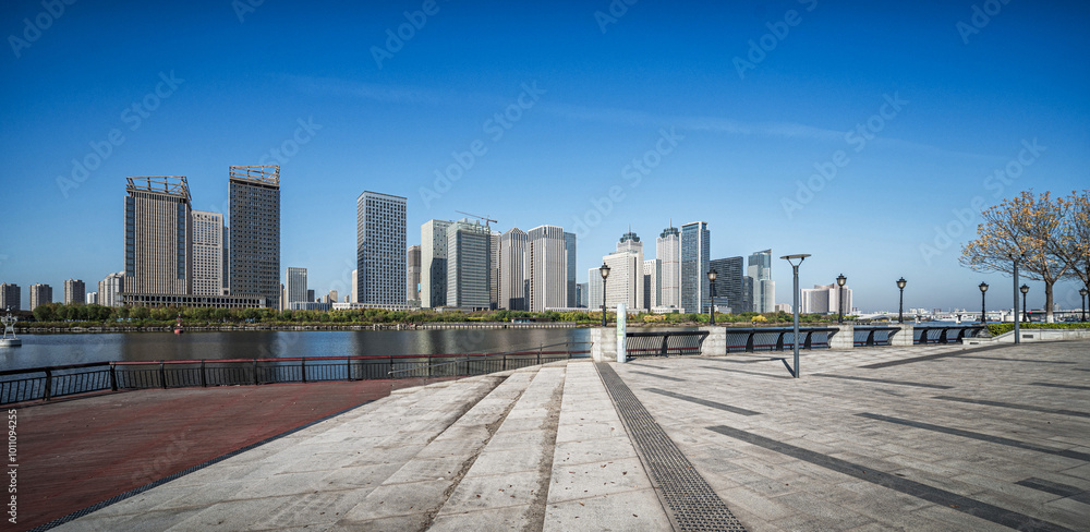 Naklejka premium Riverside Urban Skyline Under Clear Blue Sky