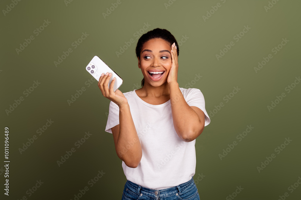 Photo of nice young woman look hold smart phone wear white t-shirt isolated on khaki color background Photo of nice young woman look hold smart phone wear white t-shirt isolated on khaki color background