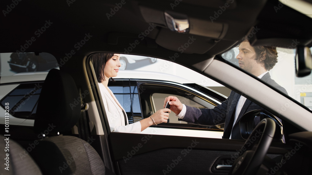 A stylish young woman enjoys her new car purchase in a modern showroom. The pleasure of driving away in her sleek vehicle highlights the joy of automotive innovation and personal freedom. A stylish young woman enjoys her new car purchase in a modern showroom. The pleasure of driving away in her sleek vehicle highlights the joy of automotive innovation and personal freedom.