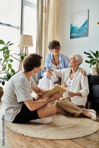 Lesbian parents and their adult son share laughter and stories in a warm, welcoming space.