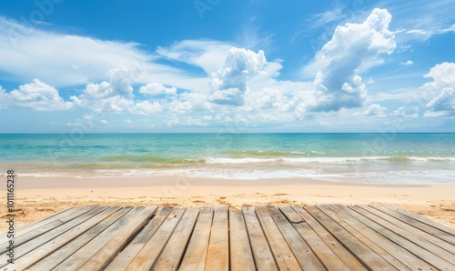 Wooden deck facing sandy beach and ocean with a bright blue sky. Summer vacation and travel concept.