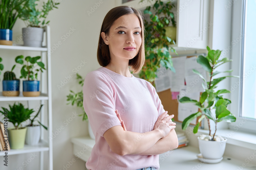 Portrait of young confident serious woman in home interior Portrait of young confident serious woman in home interior