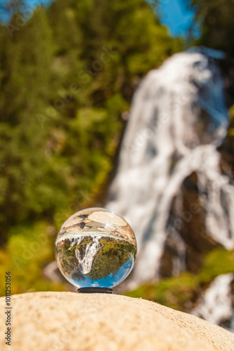 Crystal ball alpine summer landscape shot at Haslacher Schleierwasserfall waterfall, Kals am Großglockner, Lienz, Eastern Tyrol, Austria photo