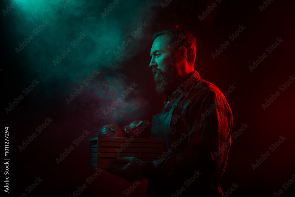 Obraz premium Photo of spooky handsome retired man hold carry pumpkin box halloween party isolated dark green red neon lights background