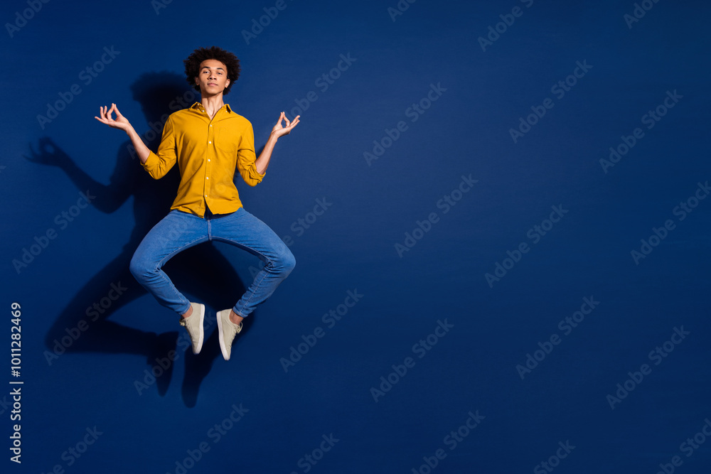 Fototapeta premium Full size photo of nice young man jump meditate isolated on dark blue color background