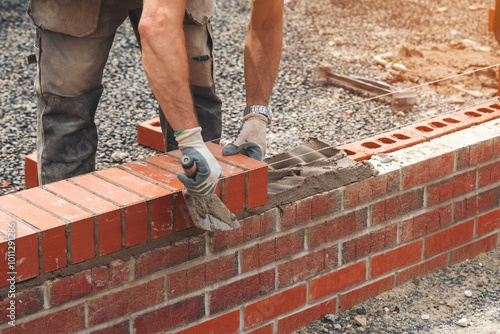 Crafting sturdy brick wall on construction site with skilled hands in the warm afternoon light