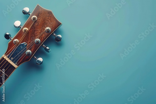 Acoustic guitar headstock on a blue background showcasing tuning pegs and wood grain texture