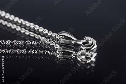 A jewelry necklace with an elegant design. Beautiful jewelry pendant with precious stones. Pendant on a black background.