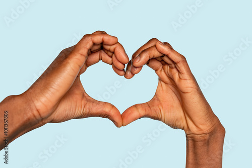 Hands forming a heart shape against a soothing blue background during a moment of connection and love photo