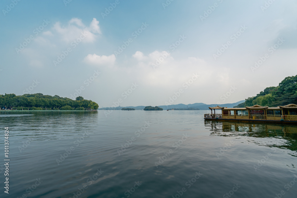 Obraz premium Tranquil Lakeside Landscape with Blue Skies and Lush Greenery