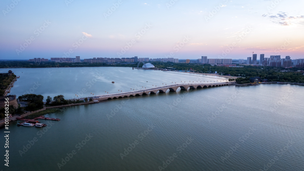 Serene Aerial View of a Cityscape at Sunset Over a Tranquil Lake Serene Aerial View of a Cityscape at Sunset Over a Tranquil Lake