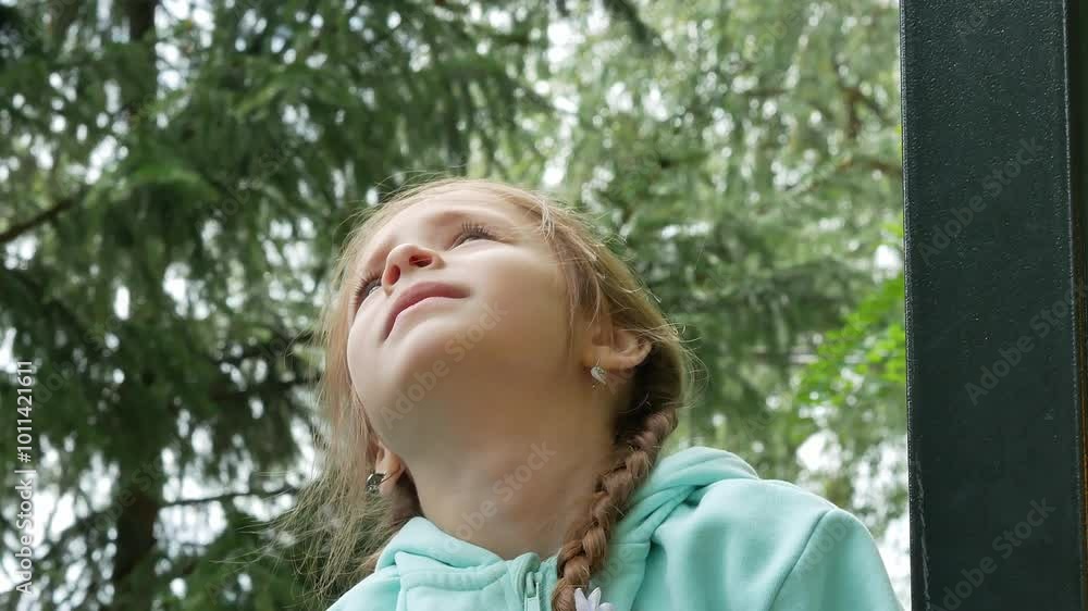Portrait of a little girl with pigtails, with big blue eyes, red hair, looking at the sky, disheveled hair fluttering in the wind. Modest. Portrait of a little girl with pigtails, with big blue eyes, red hair, looking at the sky, disheveled hair fluttering in the wind. Modest.