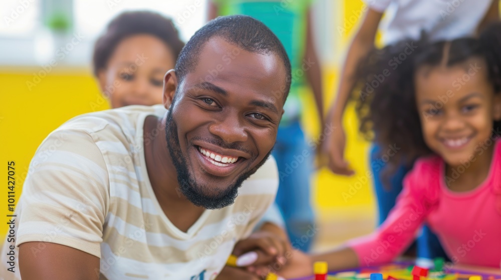 Fototapeta premium Smiling father and children playing together in a colorful room.