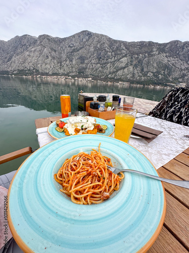 Delicious plate of pasta overlooking a tranquil mountain lake setting. Perfect blend of culinary delight and breathtaking natural beauty. Lunch time