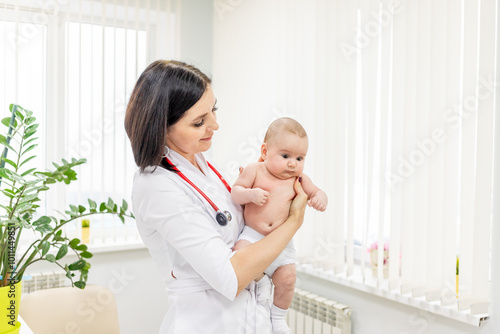 a pediatrician examines the baby in the clinic,