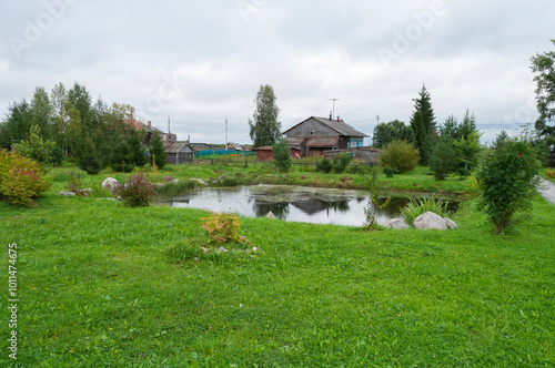 Green lawn and small pond in Lomonosov village, Arkhangelsk region, Russia