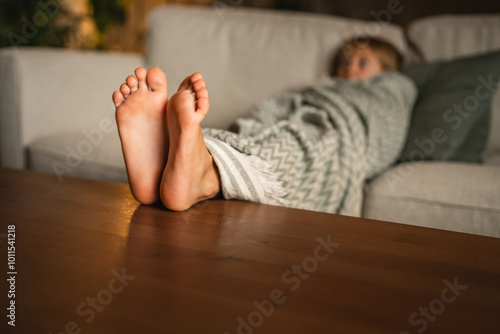 Relax young girl wrapped in blanket resting comfortably on couch photo