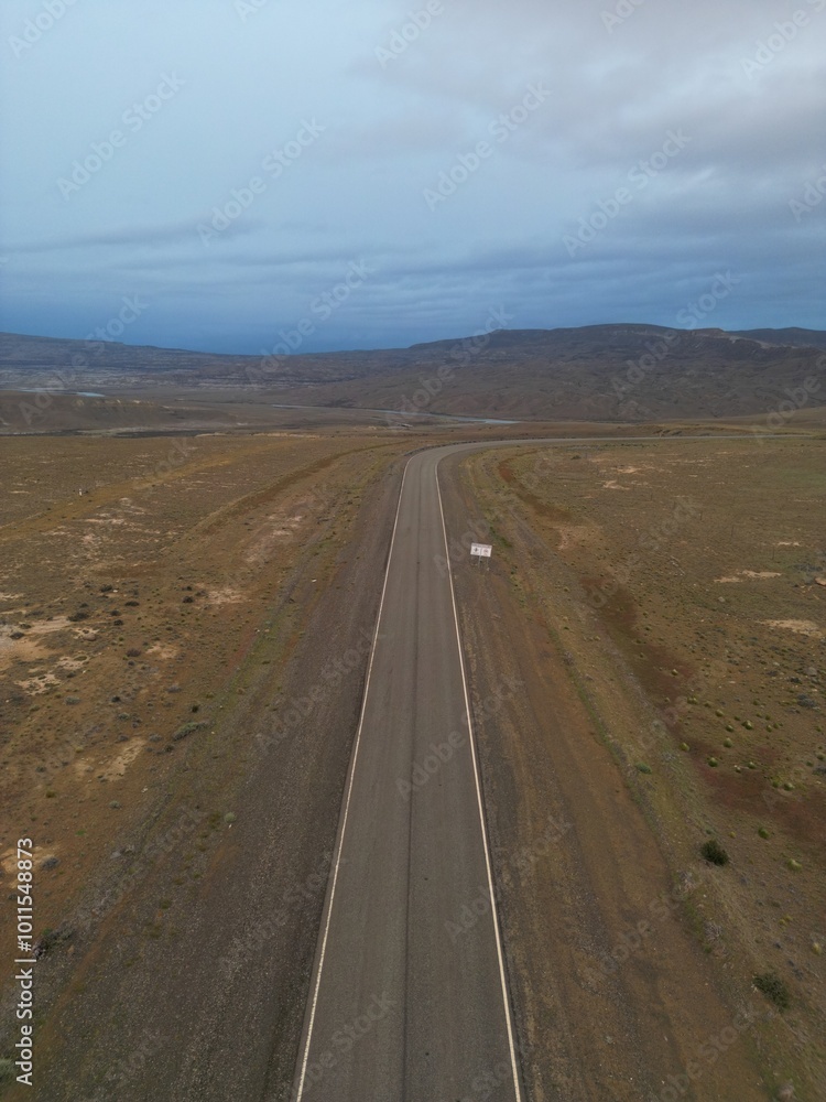 Naklejka premium Aerial views of Patagonia, Argentina, featuring barren wastelands, rugged mountains, and dry plains. The photos capture the vast, remote wilderness, highlighting the dramatic Andean peaks.