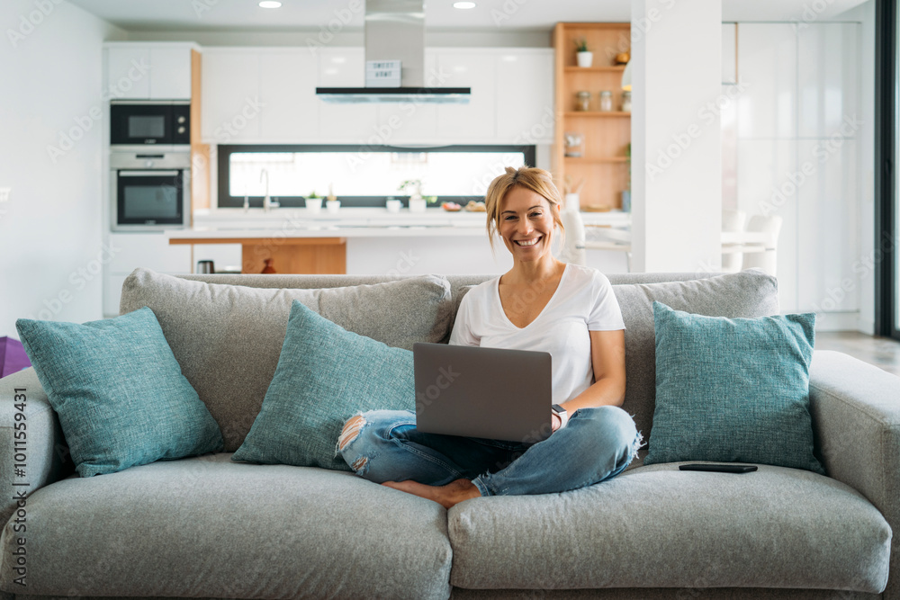 Blonde woman using laptop on sofa Blonde woman using laptop on sofa