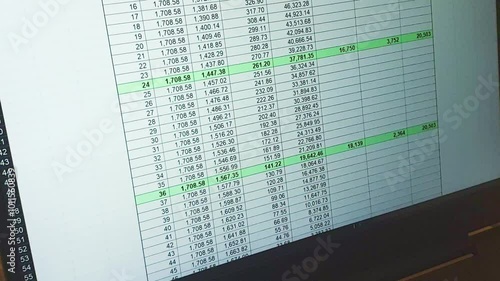 Footage of an dark mode excel sheet scrolled on computer screen showing bank loan amortization table, changing data.