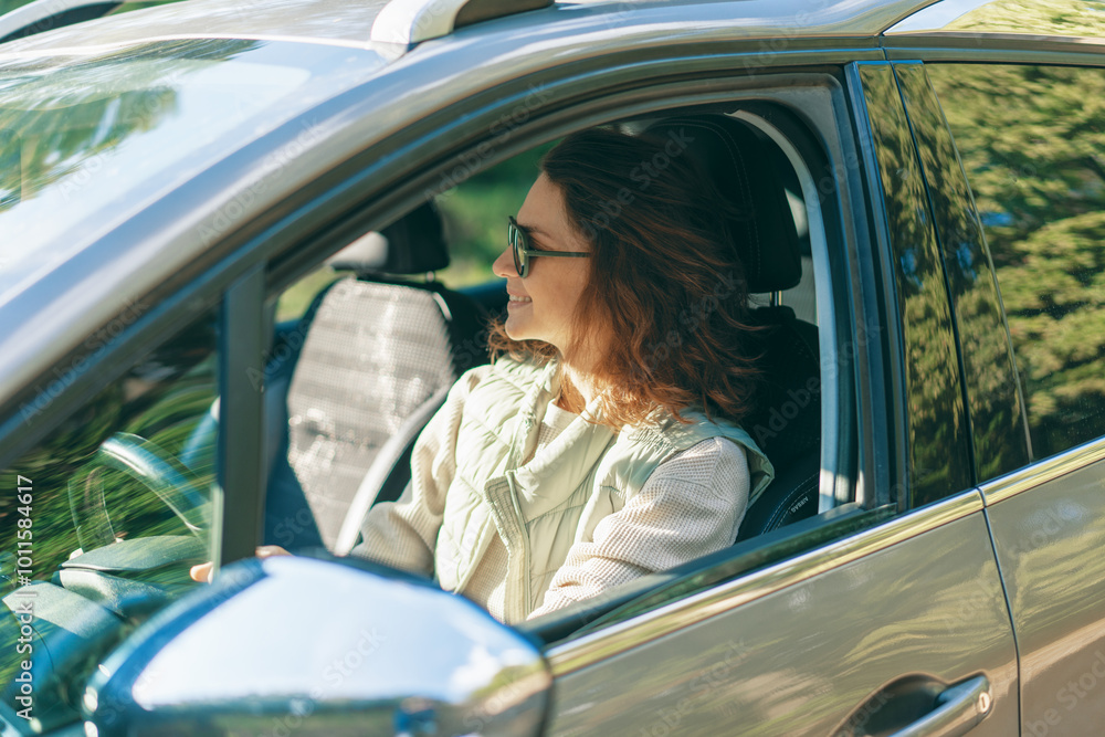 Young happy woman sitting in her car