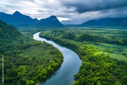 Serene Aerial View of Lush Green Landscape with Meandering River and Dramatic Mountains