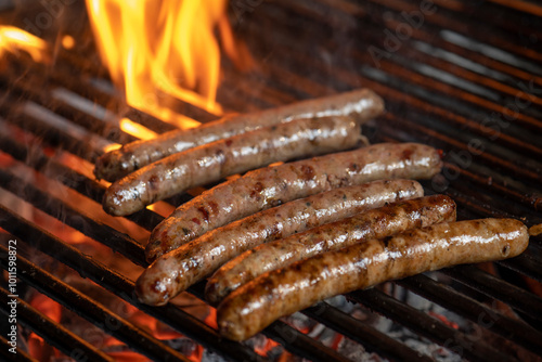 Grilling sausages on the grill with flames and smoke.