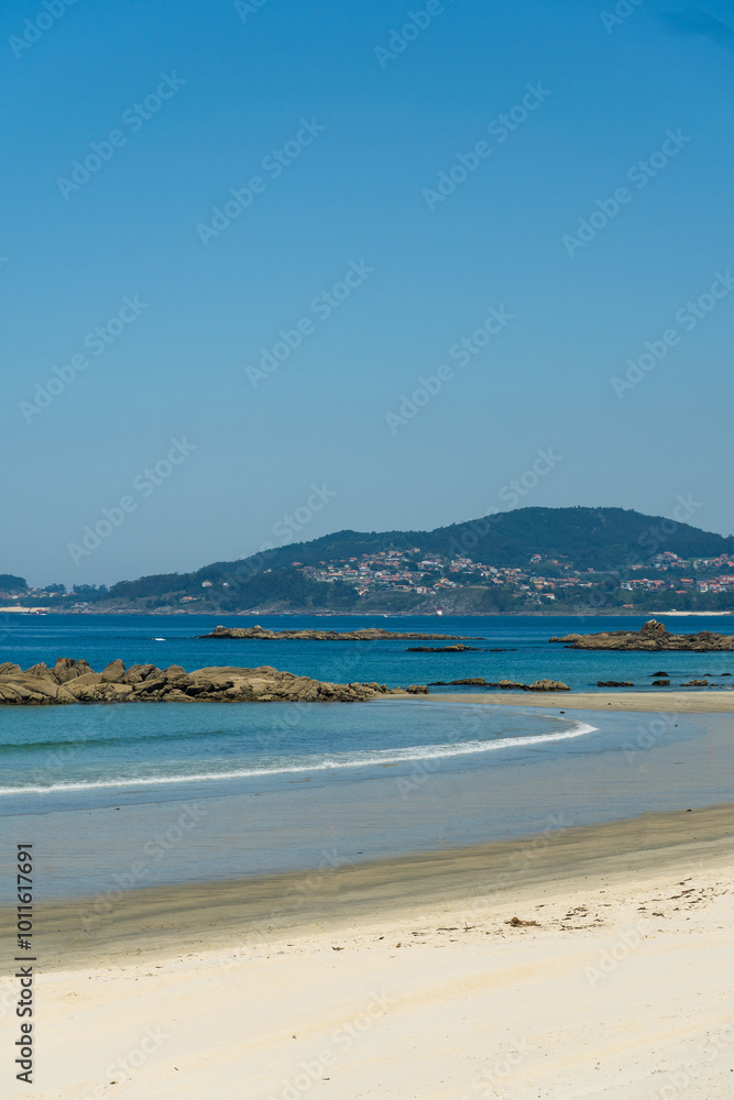 View of Playa de Samil, the main beach of Vigo in Galicia in northwest Spain. Sunny day, crystal clear blue sea View of Playa de Samil, the main beach of Vigo in Galicia in northwest Spain. Sunny day, crystal clear blue sea