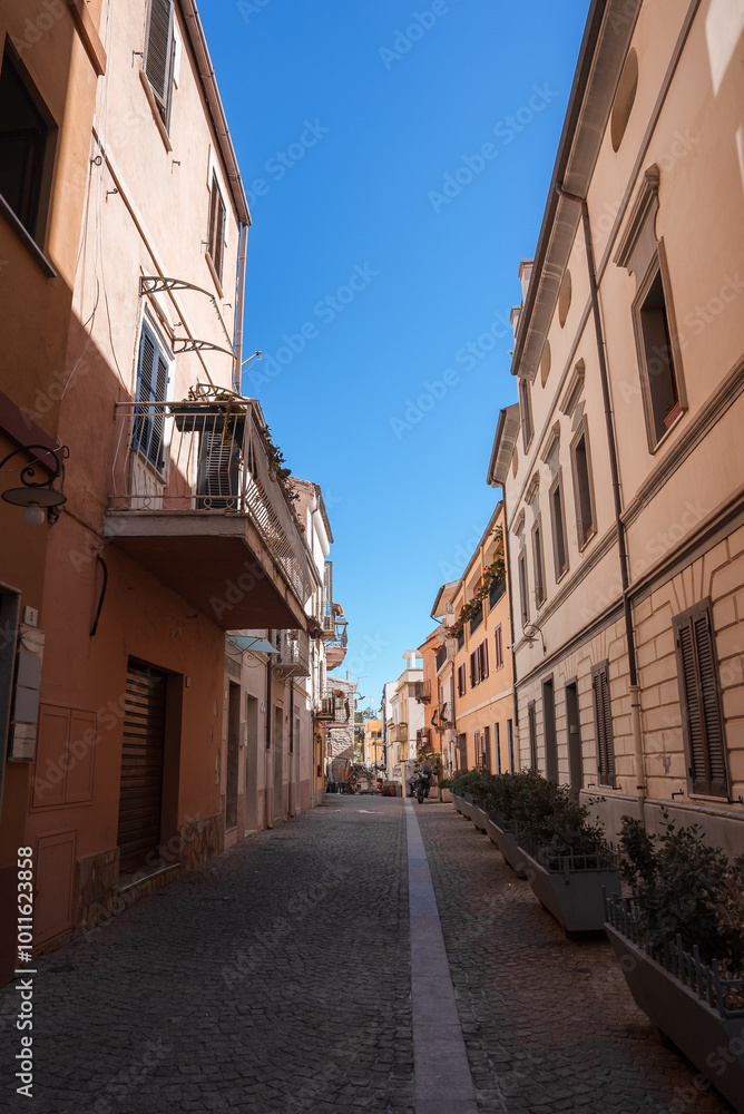 Obraz premium Charming Cobblestone Street in a Sardinian Town Under Blue Skies