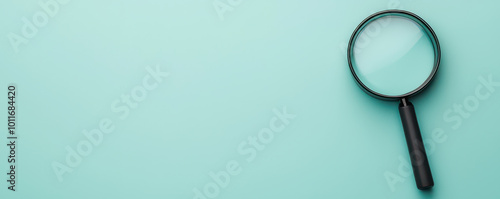 Wallpaper Mural magnifying glass rests on smooth mint green surface, symbolizing clarity and focus. This evokes sense of exploration and attention to detail Torontodigital.ca