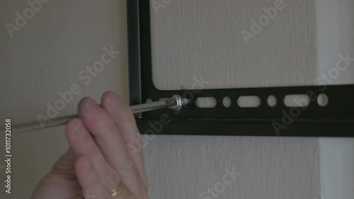 Detalle del tornillo ingresando en el soporte TV a la pared