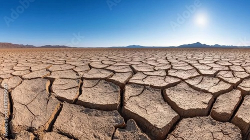 A cracked, parched earth in the middle of a severe drought, where no vegetation remains, and the sky is clear with no sign of rain