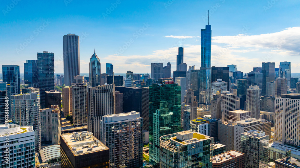 Fototapeta premium Flying up to high-rise buildings in the downtown of Chicago, Illinois, United States. Facades of the buildings are lit with bright summer sun.