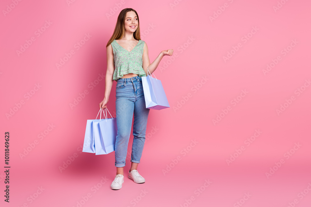Full body portrait of pretty young girl mall bags empty space wear top isolated on pink color background Full body portrait of pretty young girl mall bags empty space wear top isolated on pink color background
