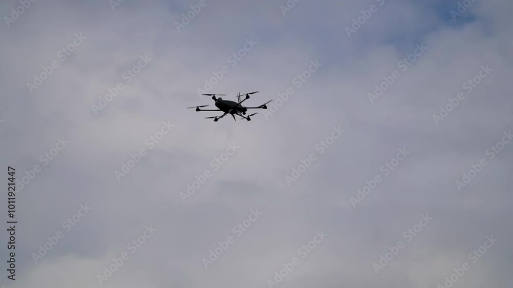 A modern Ukrainian octocopter with eight propellers flying in the sky. Military reconnaissance and surveillance by drone. A modern Ukrainian octocopter with eight propellers flying in the sky. Military reconnaissance and surveillance by drone.