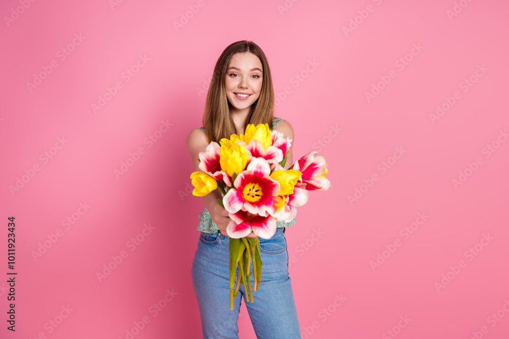 Portrait of pretty young girl give you fresh flowers wear top isolated on pink color background Portrait of pretty young girl give you fresh flowers wear top isolated on pink color background