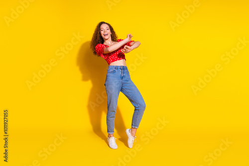 Full length photo of lovely young lady cheerful dancing have fun dressed stylish red garment isolated on yellow color background