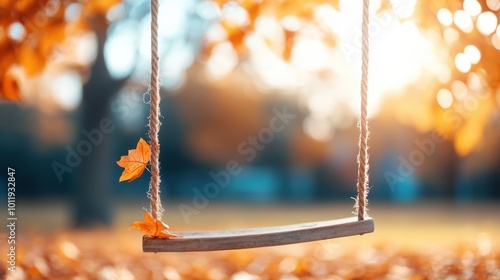 A wooden swing adorned with orange leaves hangs gently on ropes, surrounded by a blurred backdrop of golden autumn trees and soft sunlight filtering through. photo