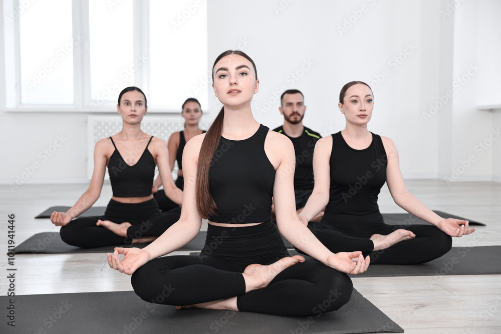 Group of people meditating on mats in yoga class Group of people meditating on mats in yoga class