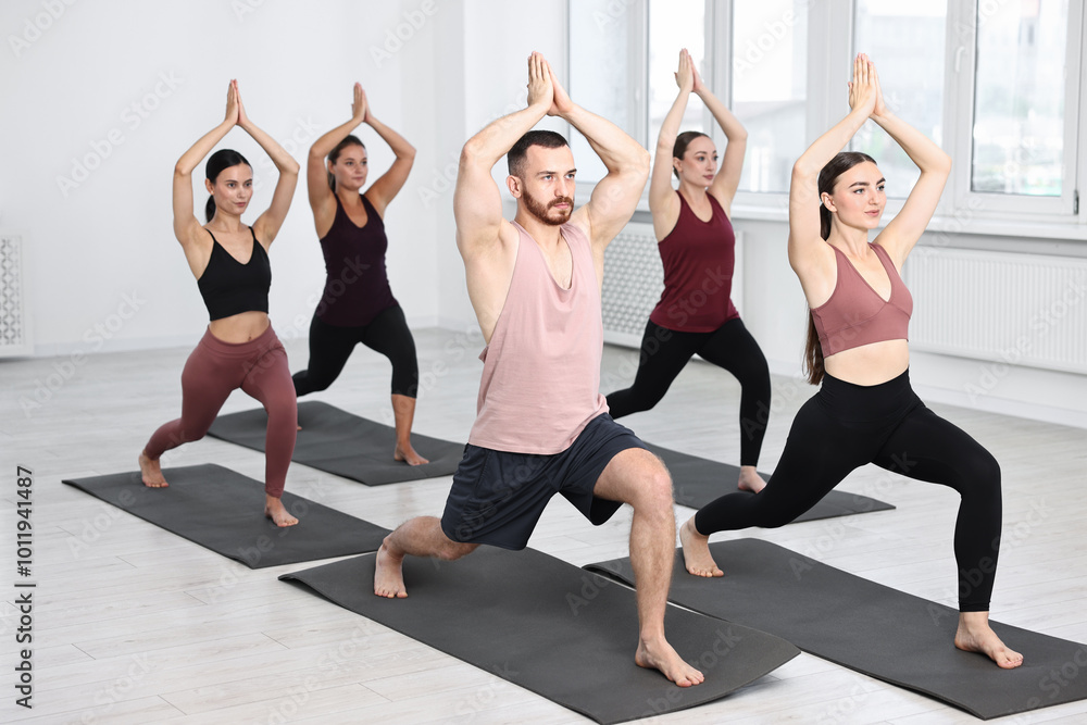 Group of people practicing yoga on mats in class Group of people practicing yoga on mats in class