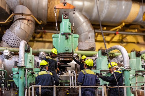 Foto The engine crew carefully transports a dismantled exhaust valve from the main engine, preparing it for inspection
