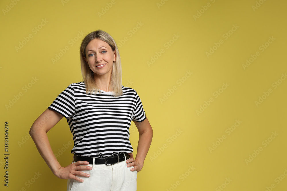Portrait of beautiful smiling woman on yellow background, space for text Portrait of beautiful smiling woman on yellow background, space for text