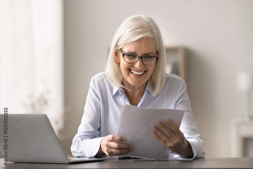 Older woman read document about positive financial statement, good balance or investments, successful project results, positive feedback, or promotion great news related to legal or official matters Older woman read document about positive financial statement, good balance or investments, successful project results, positive feedback, or promotion great news related to legal or official matters