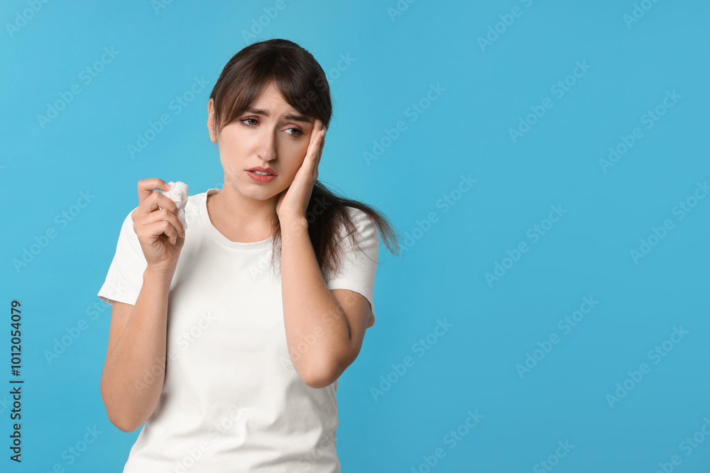 Woman with napkin suffering from sinusitis on light blue background. Space for text Woman with napkin suffering from sinusitis on light blue background. Space for text