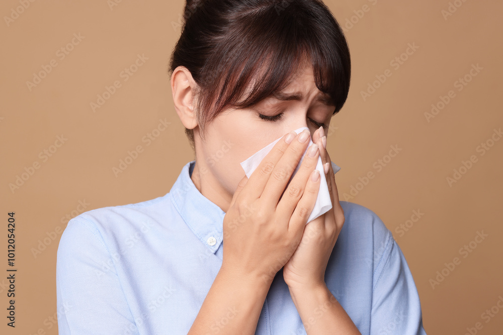Woman with napkin suffering from sinusitis on beige background Woman with napkin suffering from sinusitis on beige background